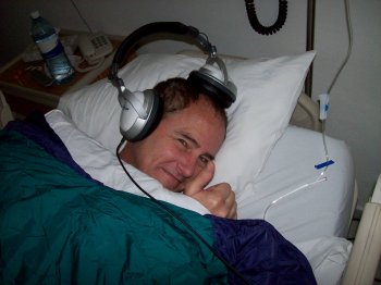Dave Clingman snuggling in bed listening to an Ender story, after his liposuction surgery at Clinica del Pilar, Guadalajara